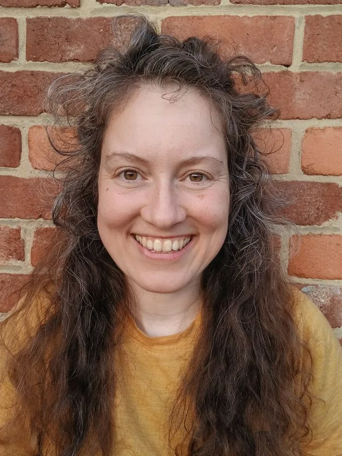 Erika, fondatrice de Das Goe, souriante devant un mur de briques